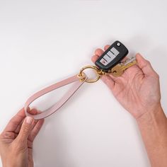 a person holding a key chain with a car remote