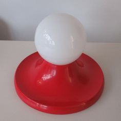 a white ball sitting on top of a red stand