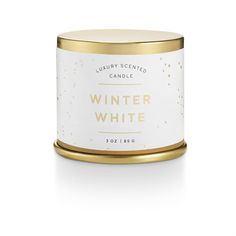 a white and gold tin candle with the words winter white on it