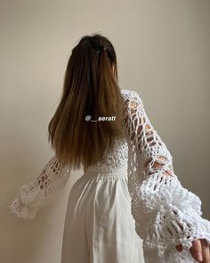 the back of a woman's head with her hands on her hips wearing a white dress