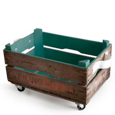 a wooden crate with wheels and handles on the bottom is painted teal, white and brown