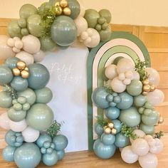 an arch made out of balloons and greenery