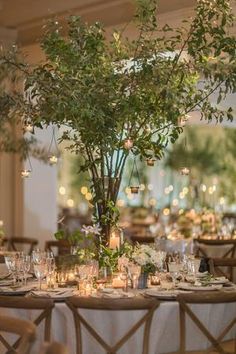 the table is set with candles and greenery