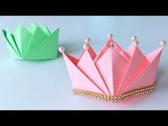 an origami crown with pearls and pearls on the sides, sitting next to each other