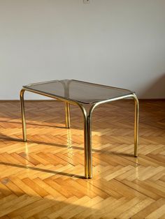 a glass table sitting on top of a hard wood floor