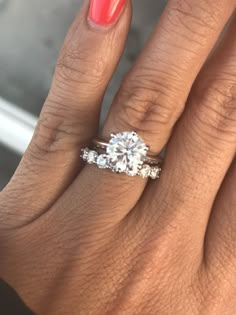 a woman's hand with a ring on it and a diamond in the middle