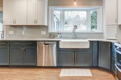 Kitchen remodel with white upper cabinets, a grey backsplash, light granite countertops, new vinyl plank flooring, and farm sink under the bay window Window Above Sink, Above Sink, Kitchen Redesign