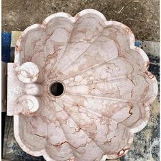 a pink marble sink sitting on top of a tiled floor