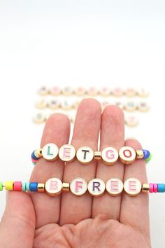 ✨The Magic is in the Details✨ Bead Size: 10mm diameter / 3.5mm thickApprox. Hole Size: 1mmNumber of beads: 1Colors: Gold Outline, White Background, Assorted Letter Colors What word or name is special to you?Spell it out in a bracelet with our trendy colorful Cutout Enamel Letter & Symbol Beads! DIY a meaningful bracelet stack and be fashionably on-trend! These alphabet beads string perfectly with all of our bone beads, pony beads, and any single-hole enamel beads.White enamel makes a bright back Stretch Bracelets Diy, Alphabet Bracelet, Alpha Bracelets, Letter Symbols, Alphabet Beads, Enamel Beads, Bracelets Diy, Beads Diy, Bone Beads