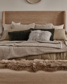 a large bed with pillows and blankets on it's headboard in a bedroom