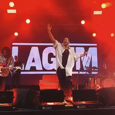 a man standing on top of a stage with his arms in the air