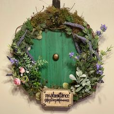 a green door surrounded by plants and flowers