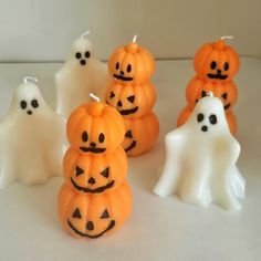 halloween candles in the shape of pumpkins with ghost faces