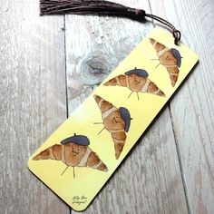 a yellow bookmark with two brown bears on it and a tassel hanging from the end