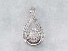 "What a fantastic piece this would be for a wedding day! This polished white gold pendant is encrusted with high-quality diamonds in a figure-eight rim and a starburst center that catch the light beautifully! This pendant does not come with the chain shown. Please feel free to contact us, we will help you find the perfect chain for your style and budget! Metal: 10K White Gold Gem: 52 Diamonds totaling .55 Carats, I2 in Clarity, H in Color Gem Measurements: 2.4 mm, Round Measurements: 25 x 13 mm, Platinum White Gold Diamond Necklace For Wedding, Dazzling White Diamond Necklace With Accents, Platinum Jewelry With Pave Setting In White, Platinum Pendant Jewelry For Weddings, Exquisite Diamond White Diamond Necklace Pendant, Exquisite Diamond White Pendant Necklace, White Gold Diamond Pendant Necklace, White Diamond Accented Platinum Necklace, White Platinum Diamond Necklace With Accents