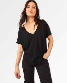 RESTOCKED- BESTSELLER! Lovely as a layer or simply styled solo, this timeless tee is sure to be your new go-to featured in an oversized, slouchy fit with V-neckline and distressing at hems for a true lived-in look. Rounded bottom hem Slightly sheer, textured fabrication Dropped shoulders for shape Specifically, this product was made with Eco-Conscious Design: It contains at least 50% of a certified eco-conscious fiber or process. We The Free Heritage inspired and lived-in staples. We The Free is Black Relaxed Fit Top With Frayed Hem, Black Distressed T-shirt For Everyday, Relaxed Fit V-neck Tops With Frayed Hem, Black Crew Neck Top With Frayed Hem, Distressed Tops For Layering With Relaxed Fit, Black Distressed T-shirt, Black Top With Frayed Hem For Summer, Everyday Distressed Black Tops, Everyday Black Distressed Top