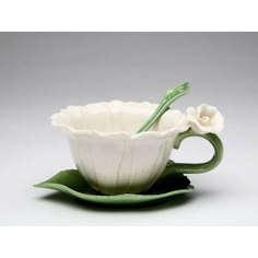 a white flower sitting in a green saucer