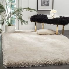 a white rug with black and gold trim on the floor in a modern living room