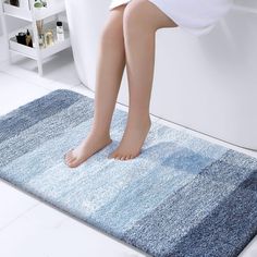 a person standing on a blue rug in the bathroom