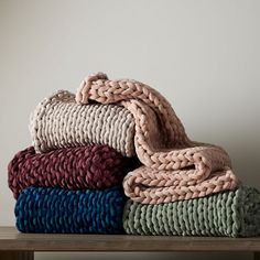 a stack of blankets sitting on top of a wooden table