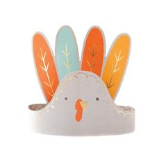 a paper turkey head on top of a white surface with orange and blue leaves around it