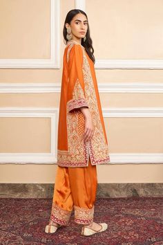 Orange pure silk chanderi A-line kurta with gota applique and kashmiri tilla embroidery. Comes with bamberg satin salwar and a silk organza dupatta with kinari finish.
Component: 3
Pattern: Embroidered
Type Of Work: Gota applique, Kashmiri tilla
Neckline: Band collar
Sleeve Type: Three quarter
Fabric: Kurta : Pure silk chanderi, Salwar : Bamberg satin, Dupatta : Silk organza
Color: Orange
Other Details: 
Short slits
Embroidered border at hem
Buttoned placket
Occasion: Mehendi and Haldi, Sangeet Transitional Designer Silk Palazzo Set, Raw Silk Palazzo Set With Straight Kurta, Designer Silk Palazzo Set With Resham Embroidery, Transitional Silk Kurta With Dabka Detailing, Semi-stitched Silk Kurta For Designer Wear, Straight Kurta Raw Silk Palazzo Set, Silk Palazzo Set With Resham Embroidery For Designer Wear, Silk Palazzo Set With Zari Work And Straight Kurta, Designer Silk Straight Kurta