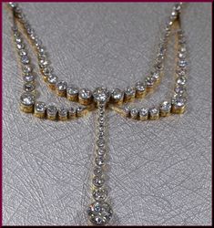 Set in 18k yellow gold, this diamond drop necklace is spectacular. Dating from the turn of the 20th century, the butterfly shaped necklace has a procession of shimmering round diamonds in alluring double curve capped off by a single line of dazzle crowed by a 1.00 ct diamond. The total weight of the necklace is 5.50 ct. The attached chain is made up of a series of bars dotted with equidistant diamonds all around. All diamonds are G/H in color and VS1/VS2 in clarity. Divinely entrancing. N 279S S Vintage Yellow Gold Diamond Necklace, Vintage Formal Diamond Necklace With Single Cut Diamonds, Vintage Yellow Gold Diamond Necklace For Formal Occasions, Victorian Diamond Necklace With Single Cut Diamonds, Antique Diamond Necklace For Weddings, Victorian Diamond Necklace With Single Cut Diamonds For Formal, Wedding Gold Diamond Lariat Necklace, Classic Lariat Necklace With 17 Jewels For Formal Occasions, Victorian Style Formal Diamond Necklace With Single Cut Diamonds