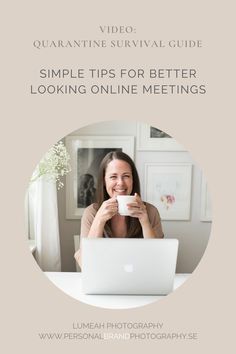 a woman sitting in front of a laptop computer holding a coffee cup and looking at the camera