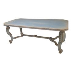 an old wooden table with blue paint on it's top and metal frame around the edge