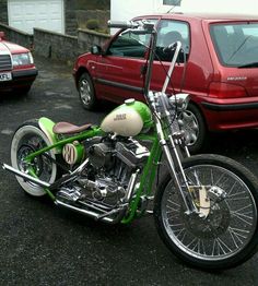 a green and white motorcycle parked in a parking lot