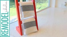 a towel rack sitting on top of a white tiled floor next to a large window