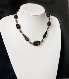 This beautiful cut glass necklace from the 1920s-1930s uses various types and cuts of glass beads which are typical of the work which was produced in the town formally known as Gablonz in Czechoslovakia, or Bohemia.  The main brown beads swirled with black use a technique known as givre glass. They are probably intended to imitate smoked topaz. It measures 17" = 43cm long. The largest bead measures 30mm x 15mm = 1.1" x0.6 inches. Overall the necklace is in great condition with a few little nicks Art Deco Necklace, Antique Necklace, Stunning Necklace, Glass Bead Necklace, Necklace Vintage, How To Make Earrings, Glass Necklace, Vintage Jewellery, Czech Glass Beads