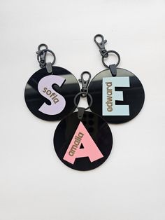 three different key chains with letters on them