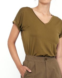 A basic that every wardrobe must have. The Signature V-Neck Tee features a deep v-neck, cuffed short sleeves, and a loose, easygoing fit. It’s made from a lightweight and breathable tencel spandex material with an ultra soft silk-like touch. Hangs elegantly off the body. + Details Color: Kelp, Olive, Beige, Black 95% Tencel, 5% Spandex XS, S, M, L, XL Ananda is 5'7" and wearing a S Hand wash cold, lay flat to dry. Can be machine washed cold. Do not tumble dry. Can be dry cleaned. + Material A te Knitwear Dress, Secret Sale, Cuffed Shorts, Feather Light, Signature Collection, Guangzhou, V Neck Tee, Signature Style, Lay Flat