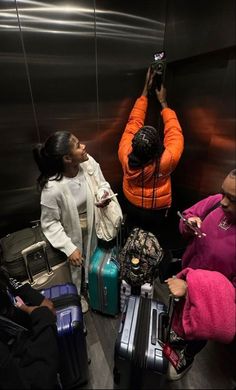 people standing around with their luggage in an elevator