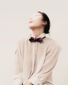 a woman with her eyes closed wearing a bow tie