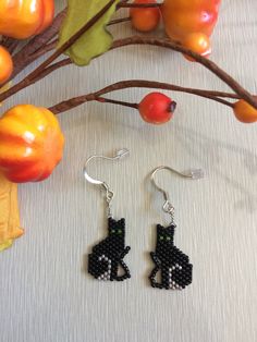 a pair of black beaded earrings sitting on top of a table next to fruit