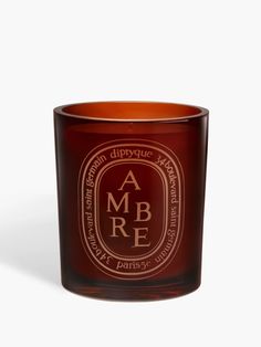 an orange glass candle with the words ambre on it