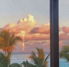 the view from inside a window looking out onto the ocean and palm trees at sunset