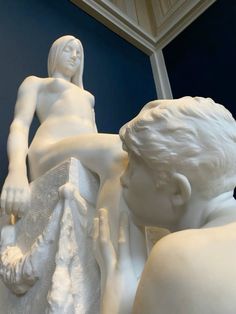 there is a white statue that looks like a man and woman next to each other