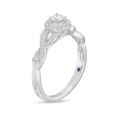 a white gold engagement ring with an intricate design and blue sapphire stones on the band