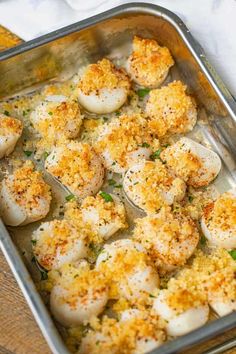 a metal pan filled with cooked scallops covered in parmesan cheese