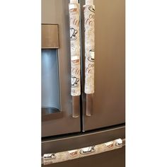 two rolls of wrapping paper sitting on the side of a refrigerator freezer in a kitchen