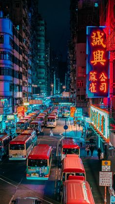 a city street filled with lots of traffic next to tall buildings and neon signs at night