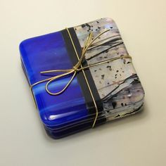 a blue and black box wrapped in gold string