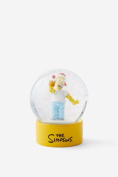 a snow globe with an image of a person inside it on a yellow base and white background