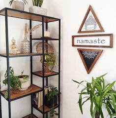 a shelf filled with plants next to a sign that says namaste on it