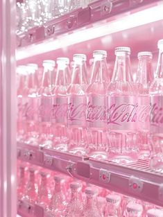 a pink vending machine filled with lots of coca - cola bottles and empty glasses