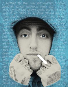 a man with tattoos holding his hands to his face and looking at the camera while wearing a blue hoodie