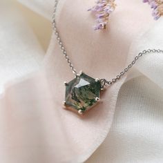 Be special with our moss agate necklace made in a delicate and minimalist style. Please choose the material and length from the drop down menu. In case if you prefer other shape or different gemstone - feel free to contact me, I will be happy to create custom hexagon shaped necklace.✨ Product details: Gemstone: Moss agate Measurements: 10x10mm Shape: Hexagon Material: 14k gold/Silver Total weight: 2.5g 🛠Handcrafted with love from our workshop in Prague.🛠 CERTIFICATION📃 Each piece of jewelry i Minimalist Pendant Necklace With Natural Inclusions, Elegant Moss Agate Pendant Necklace, Minimalist Agate Gemstone Necklace, Green Octagon Necklaces As Gift, Green Octagon Necklace For Gift, Elegant Faceted Hexagon Necklace, Elegant Hexagon Faceted Necklace, Handmade Hexagon Necklace For Gift, Hexagon Gemstone Necklace As A Gift